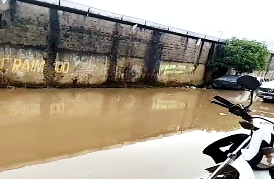 Moradora mostra rua alagada no bairro do Amparo em Santo A. de Jesus